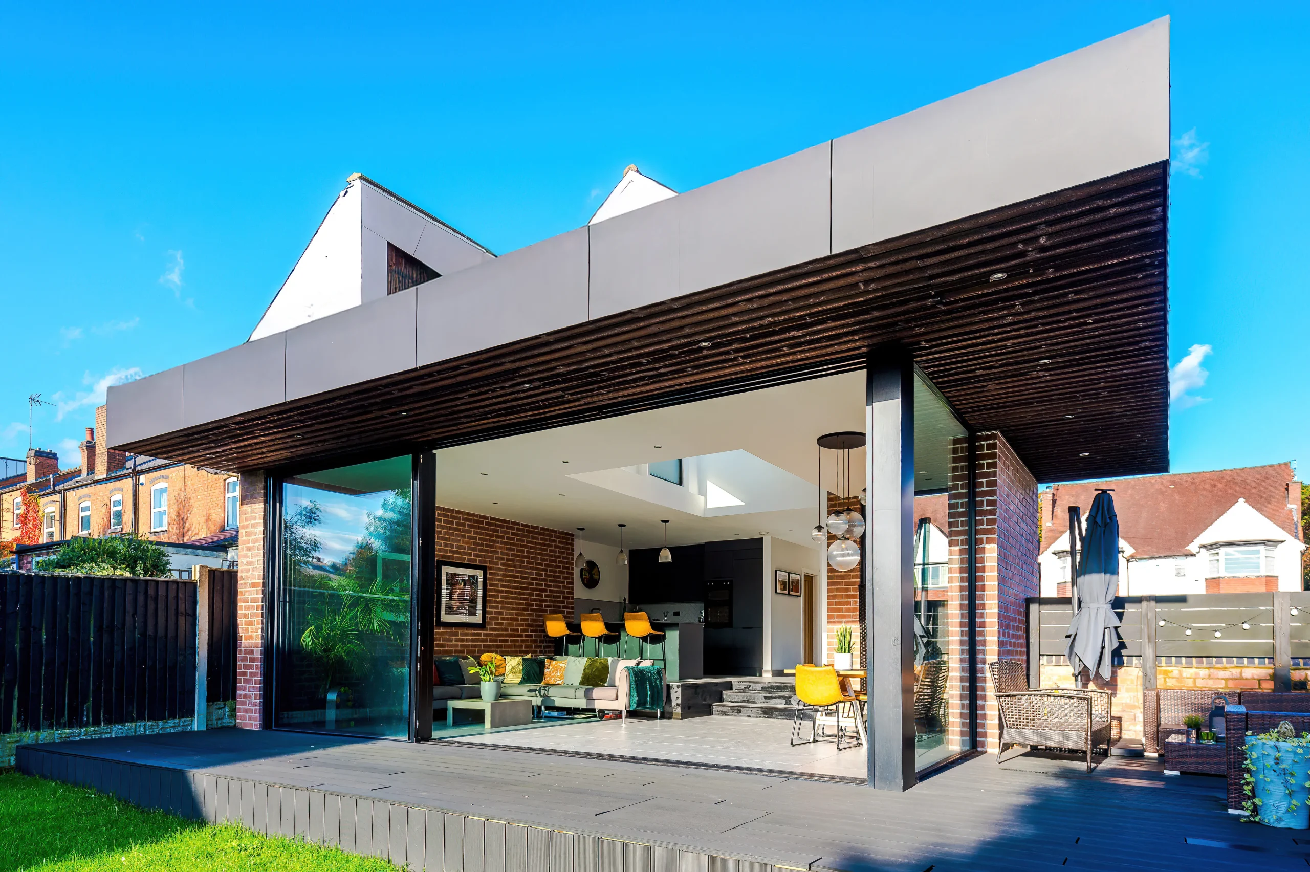 View of deep canopy over deck with large sliding doors and corner glazing