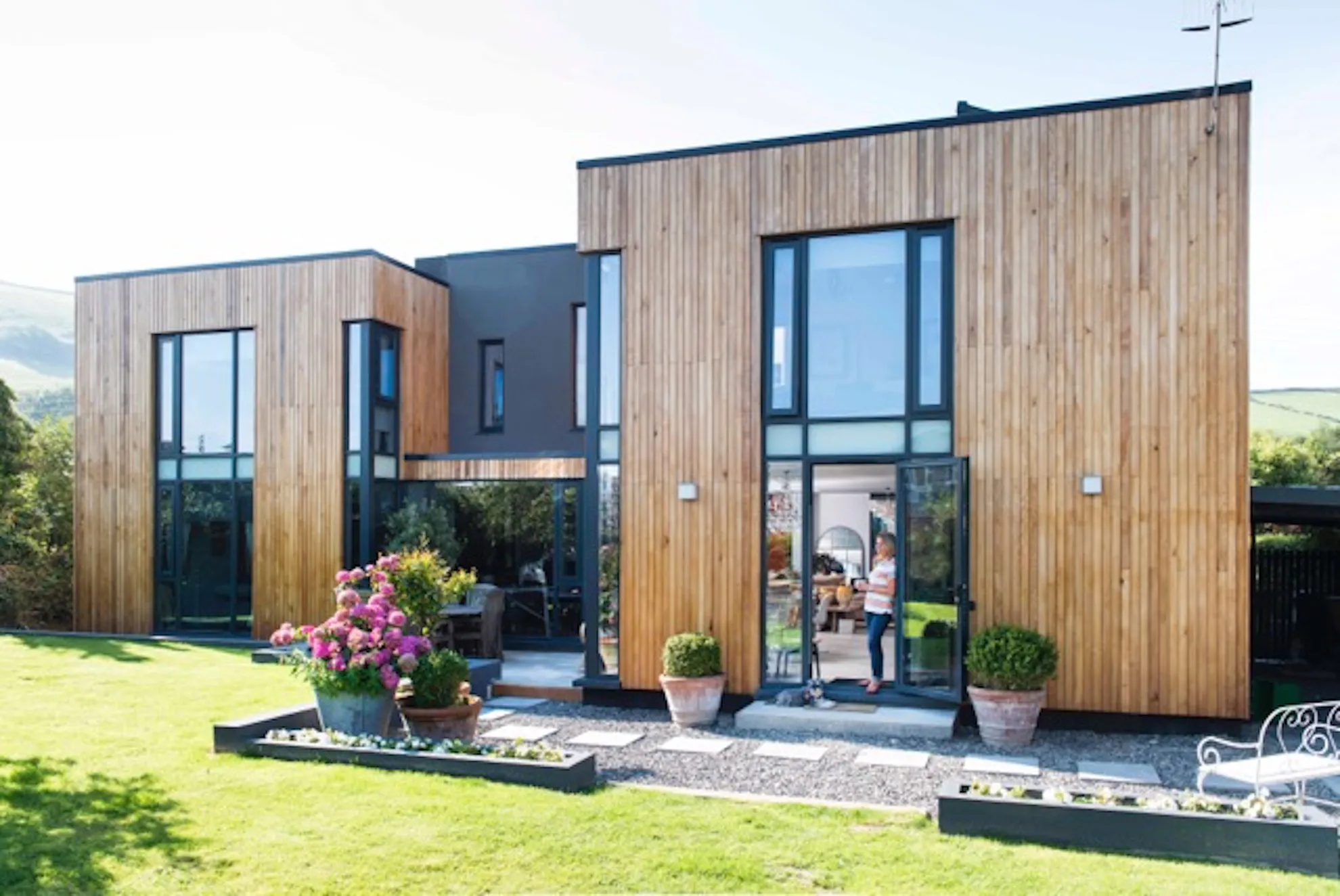 Rear showing timber clad side cubes wrapping across dark grey rendered central section