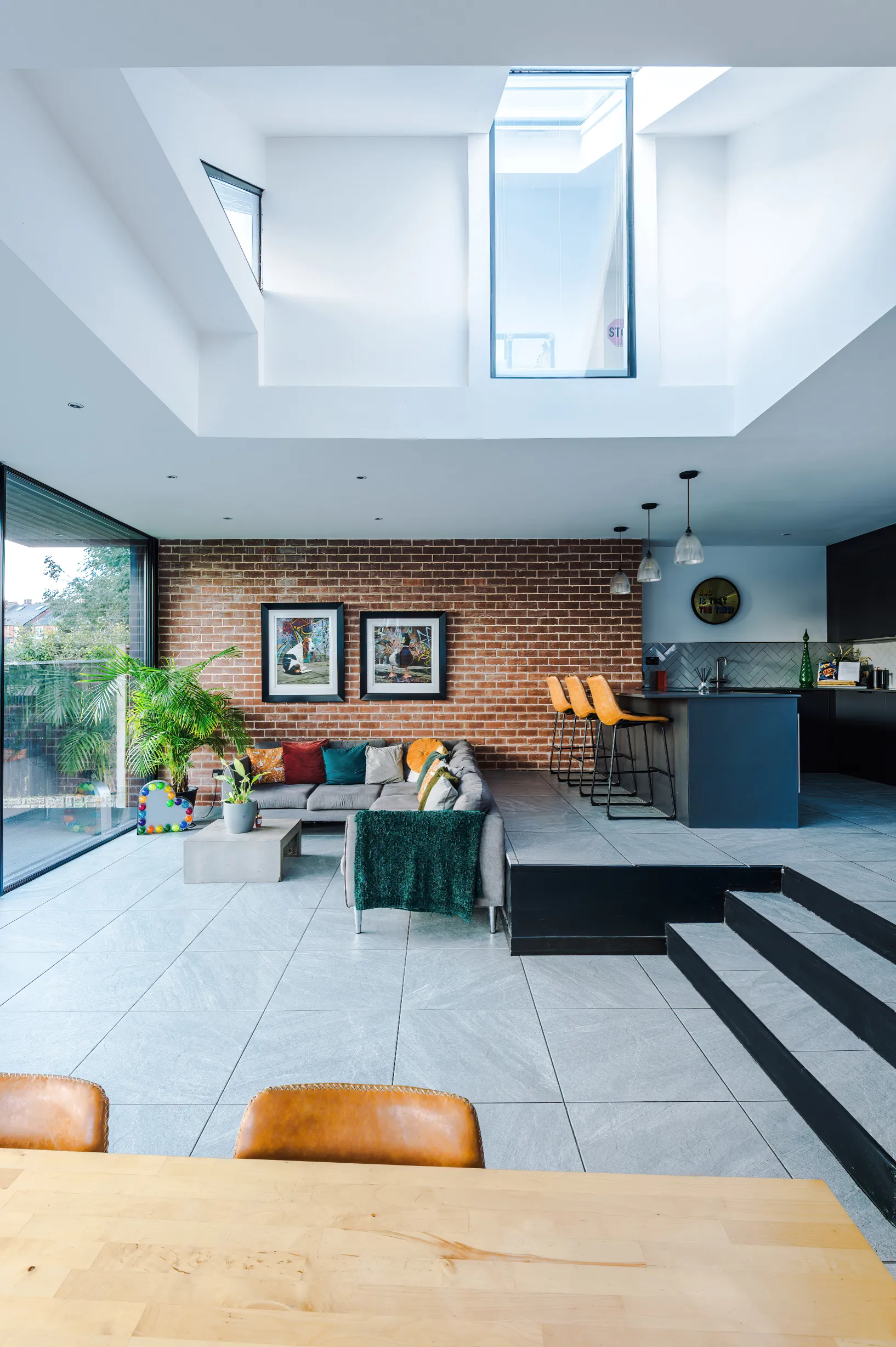View of split level kitchen and lounge, with double height space over