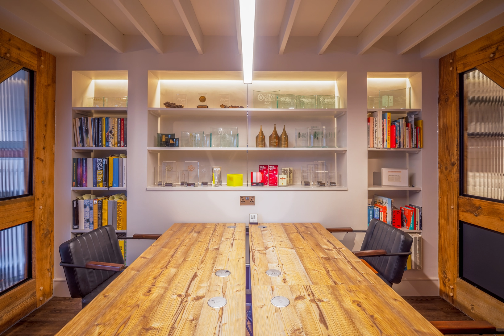 Shared workstation with repurposed roof trusses either side forming privacy screens