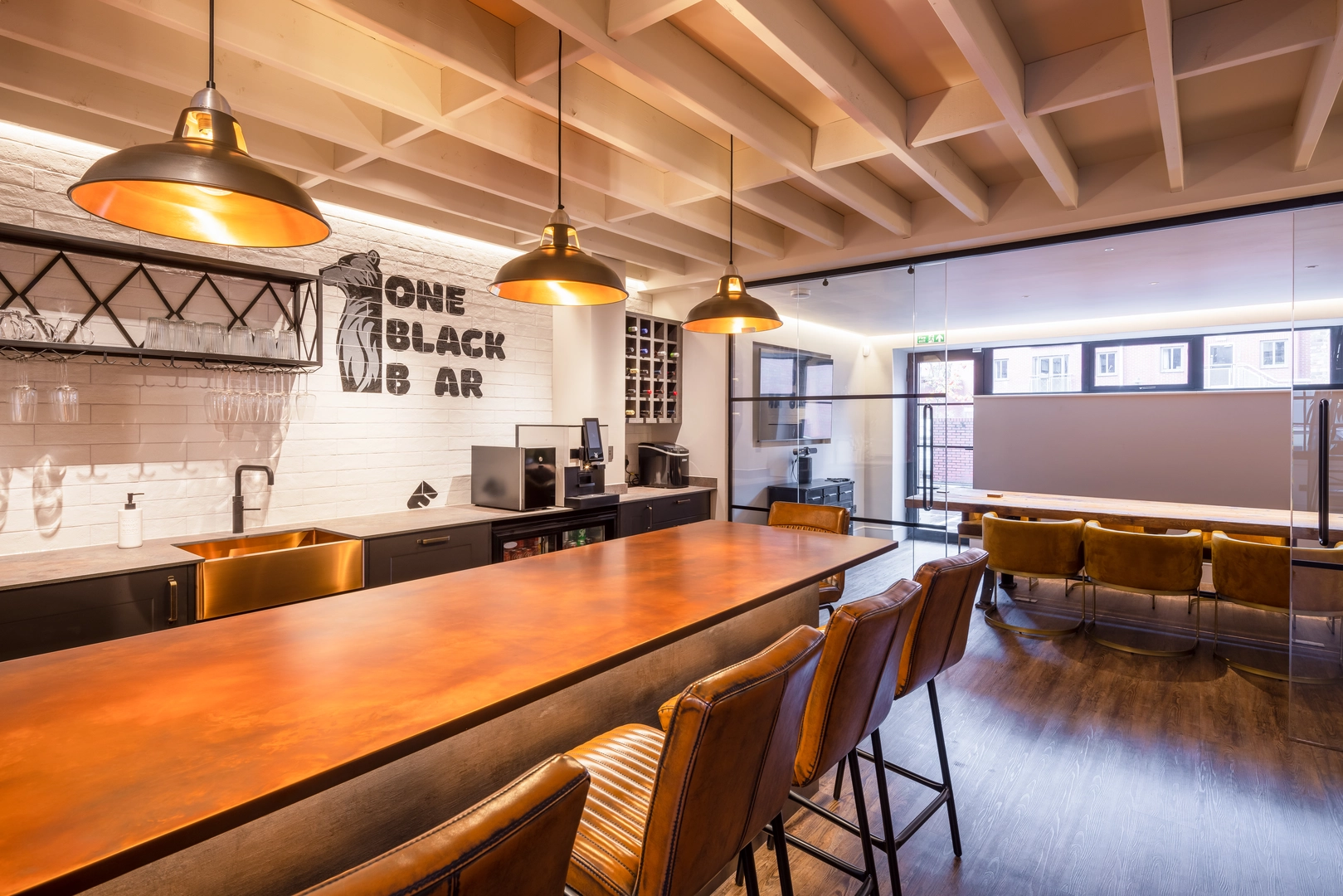 View of the bar, with the conference room beyond. Exposed floor joists provide a coffered ceiling