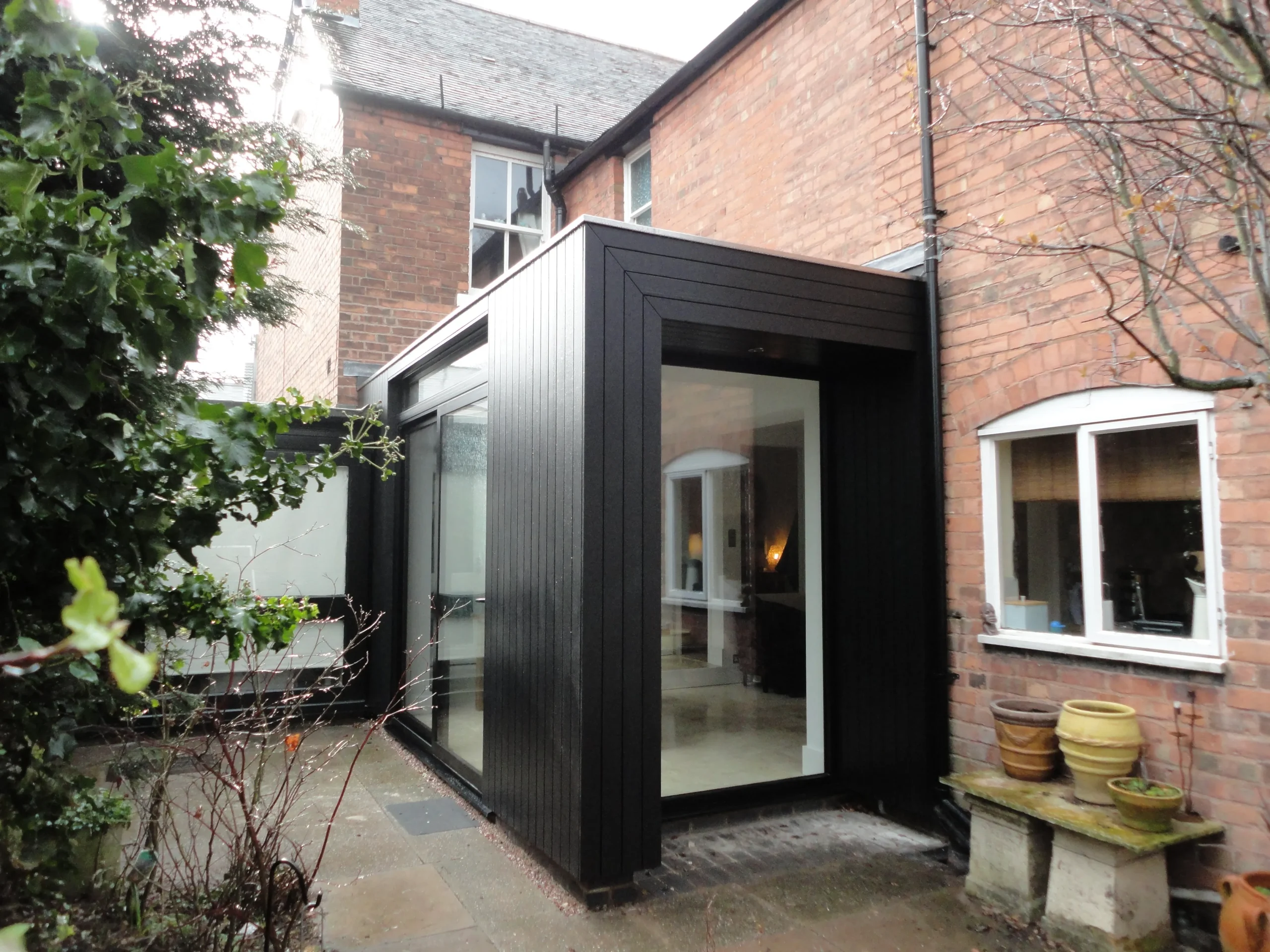 Black stained timber clad extension to dining room