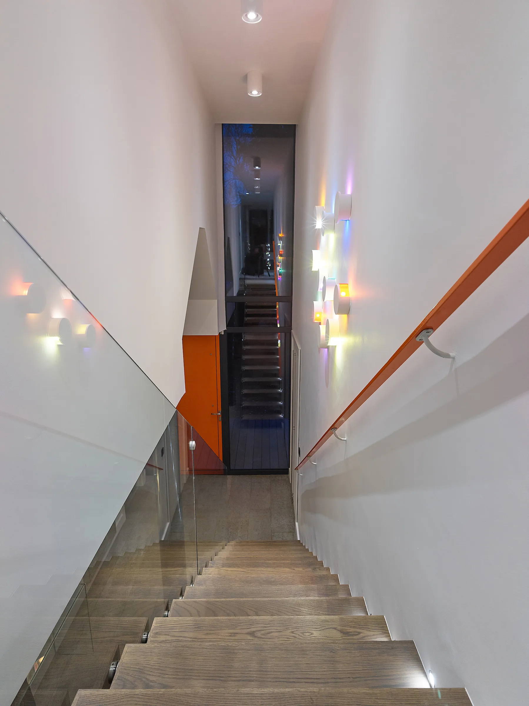 Double height entrance hall with cantilevered stairs and glass balustrade