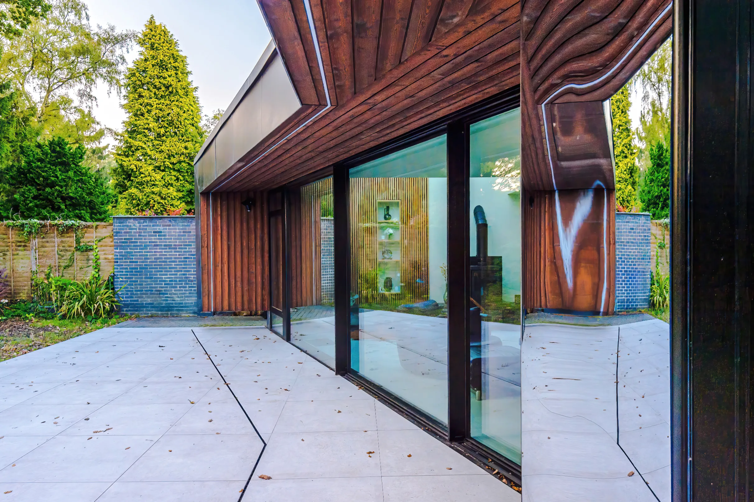 Deep canopy clad in charred larch and reflected by the feature mirror cladding.