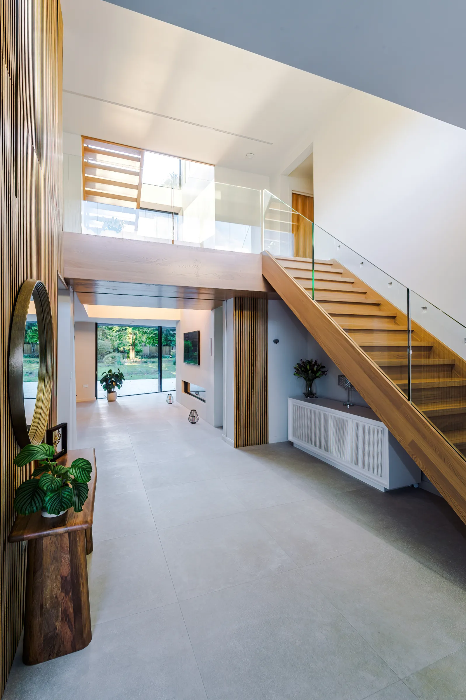 Remodelled entrance hall featuring double height space, timber stair, and timber wall cladding
