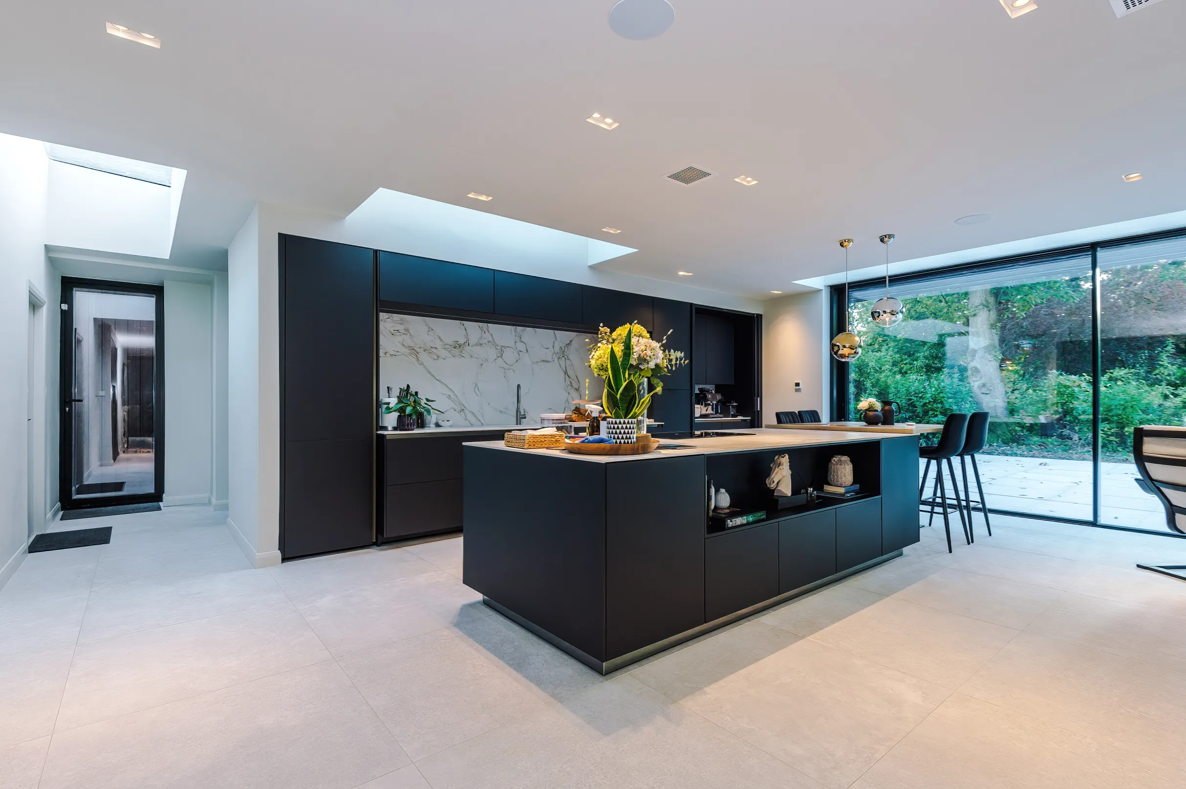 Black kitchen with central island and 3 rooflights.