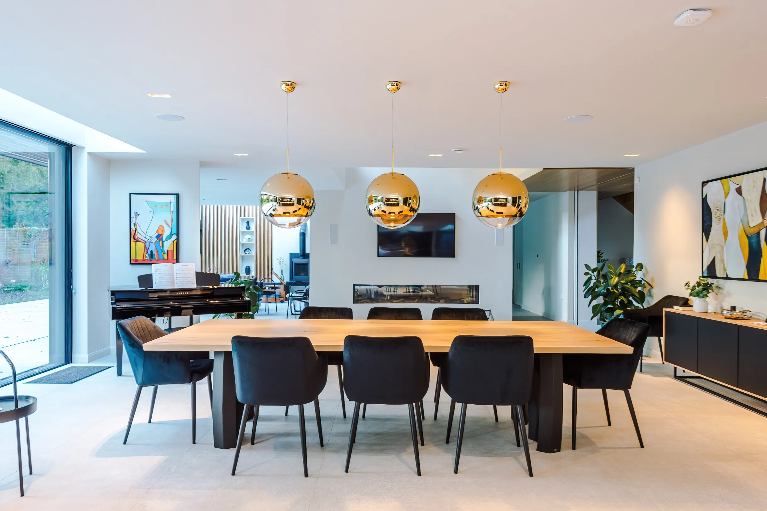 Open plan space linking the dining zone in the foreground and music, exercise, and lounge zones to the rear.