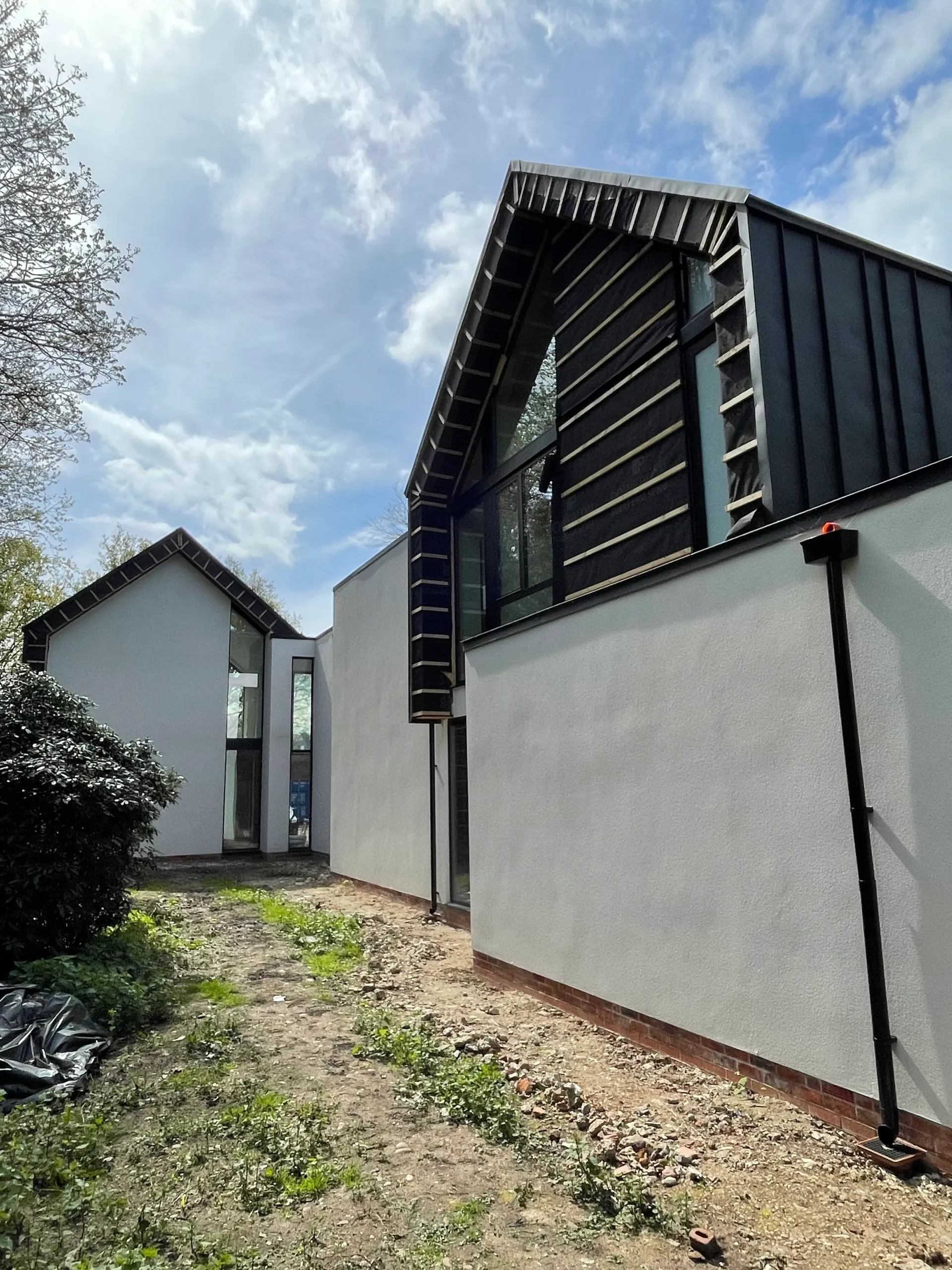 Rear view where zinc clad roofs meet rendered base.