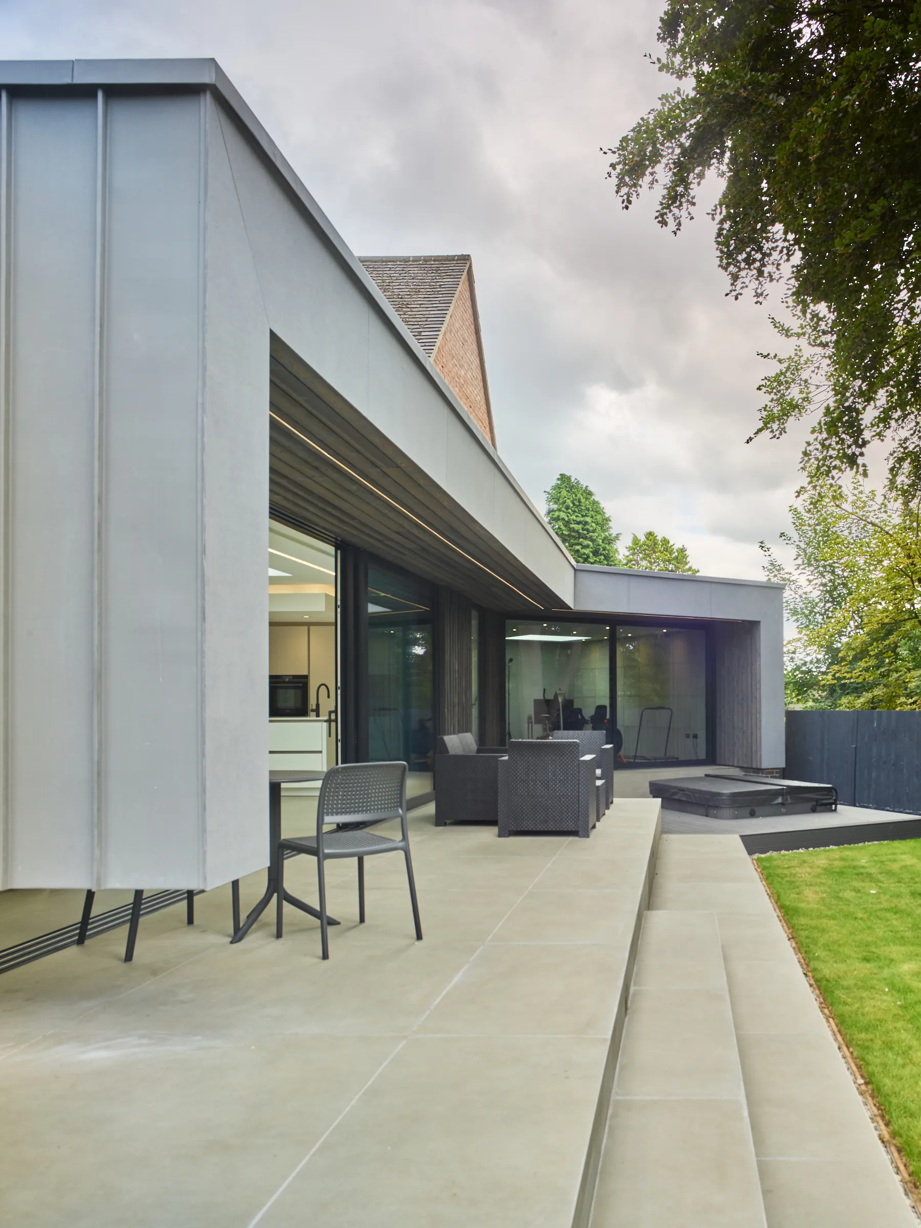 View of the rear extension featuring a deep zinc clad canopy and raised terrace