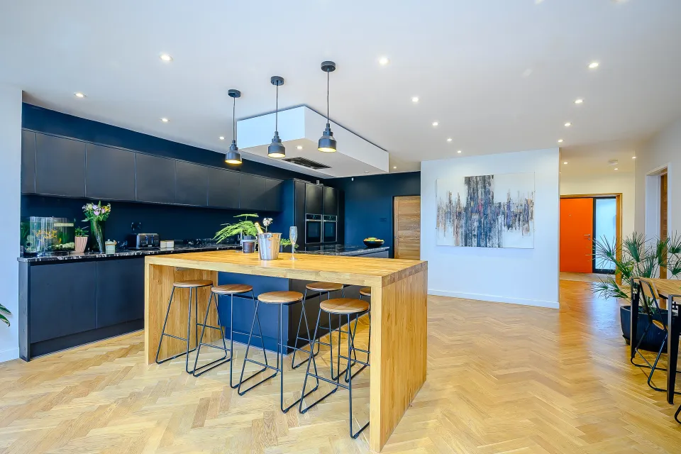 Black kitchen linked spatially to entrance hall