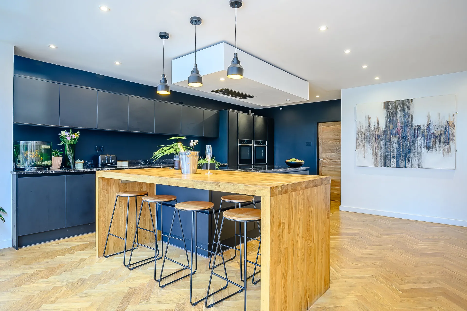 Black kitchen linked to entrance hall