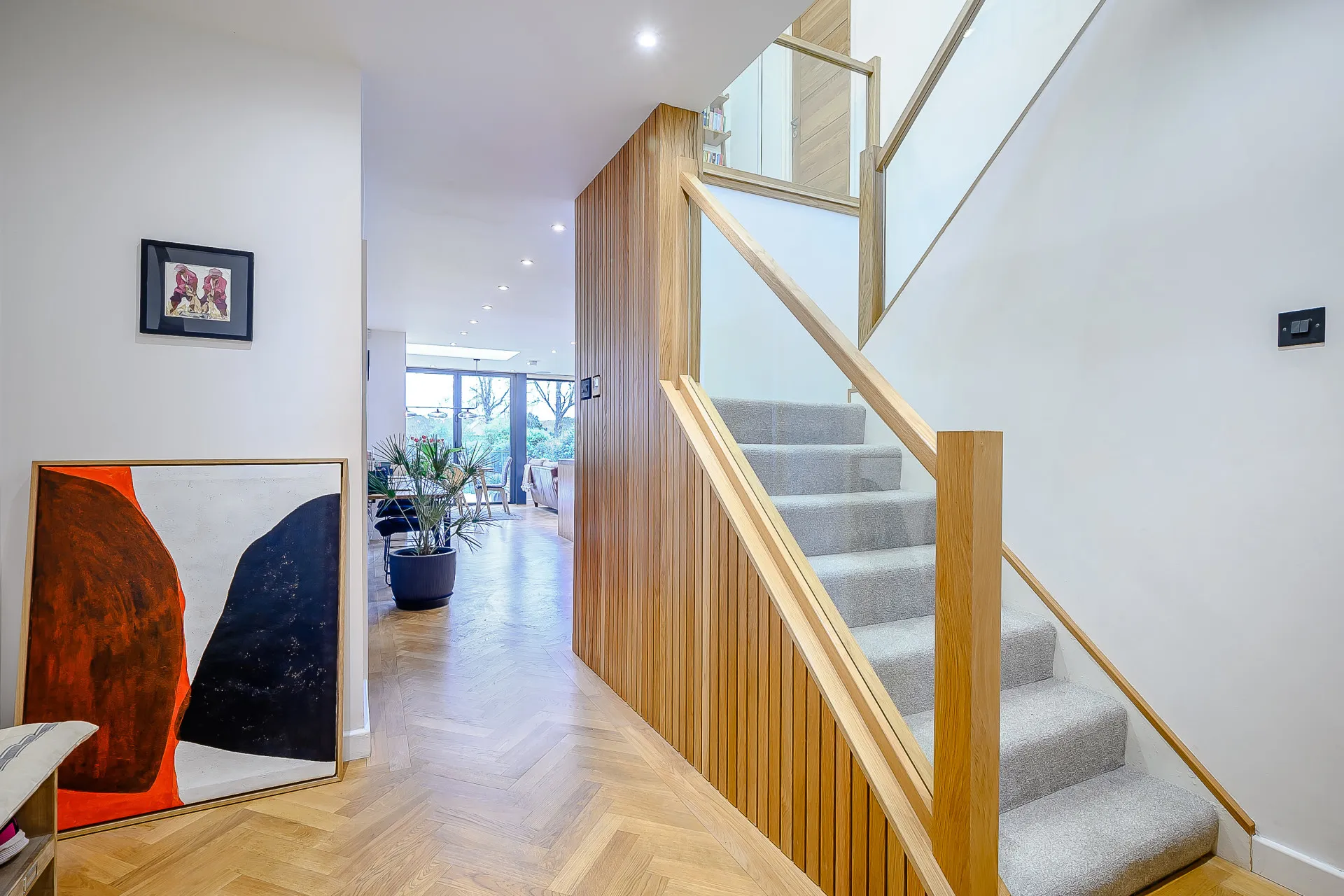 Entrance hall with timber clad stair feature, linking to open plan space