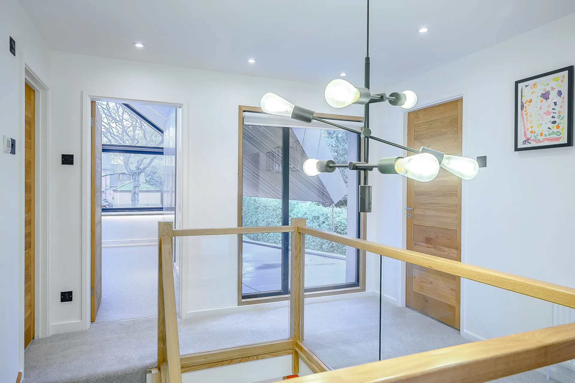 Landing with glass balustrade and view of roof overhang
