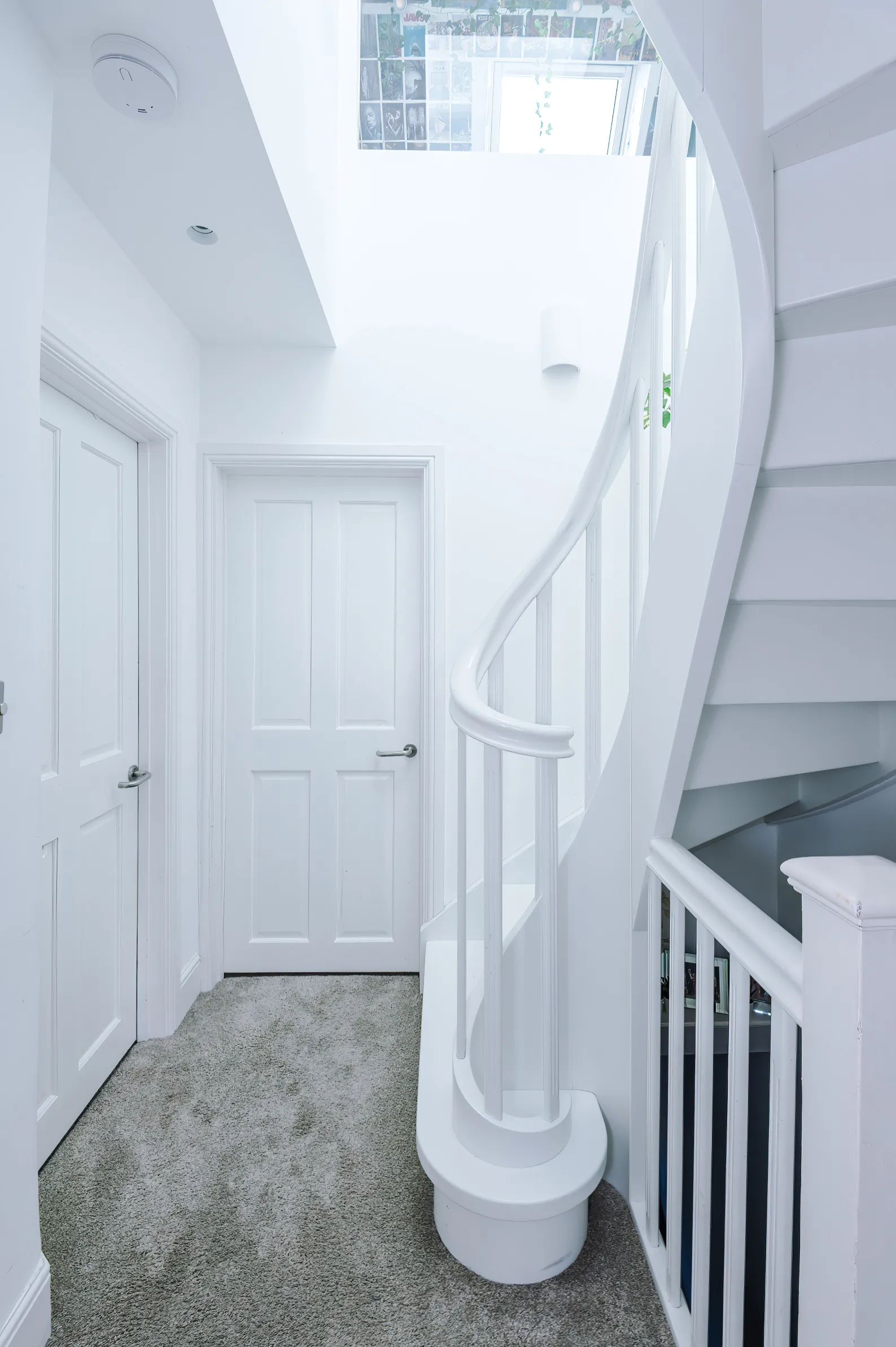 The landing features a winder stair, double height space, and internal window and a rooflight above flooding the space with light.
