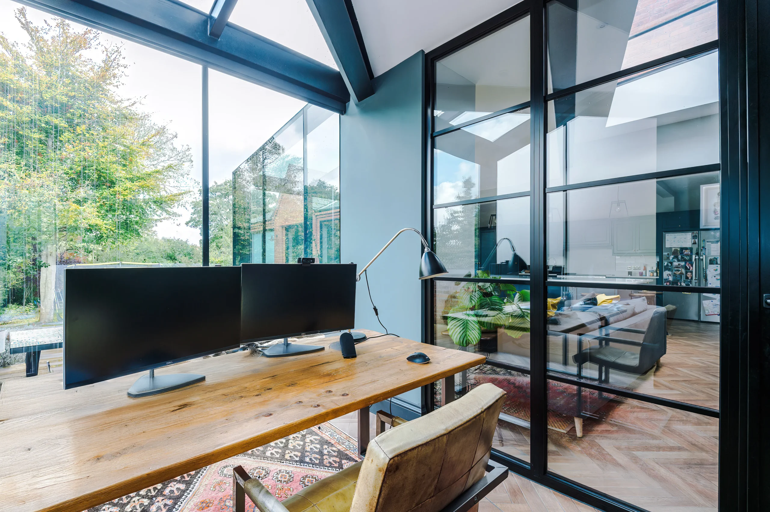 View of the home office separated from the open plan space by a crittall style glazed screen