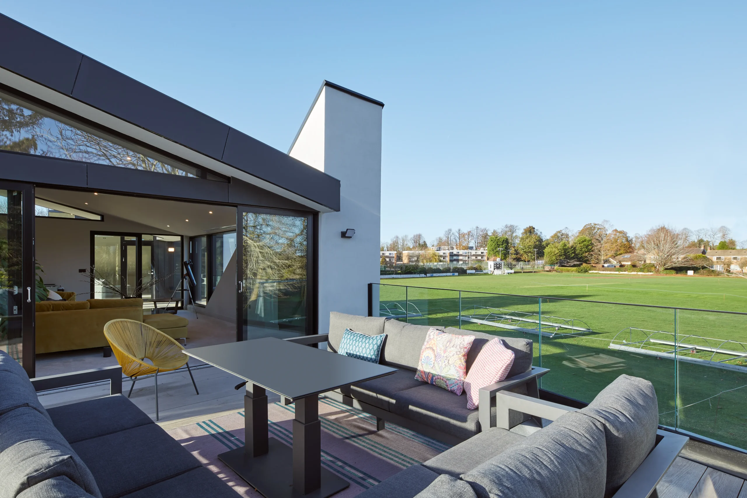 First-floor terrace overlooking the cricket ground with glazed balustrade and direct connection to the elevated living space