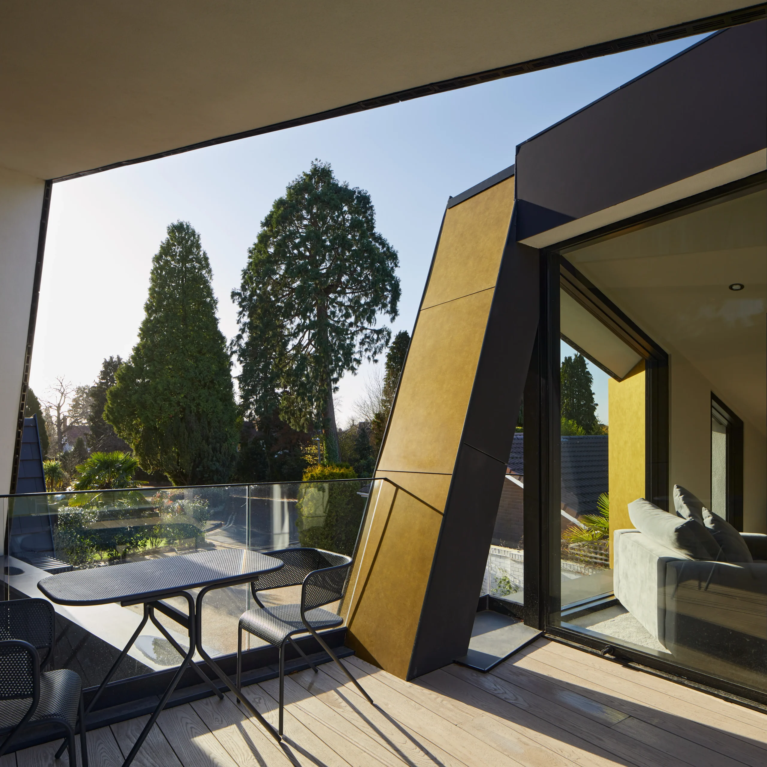 Close-up of first-floor terrace framed by wrapping canopies with views over surrounding trees and landscape