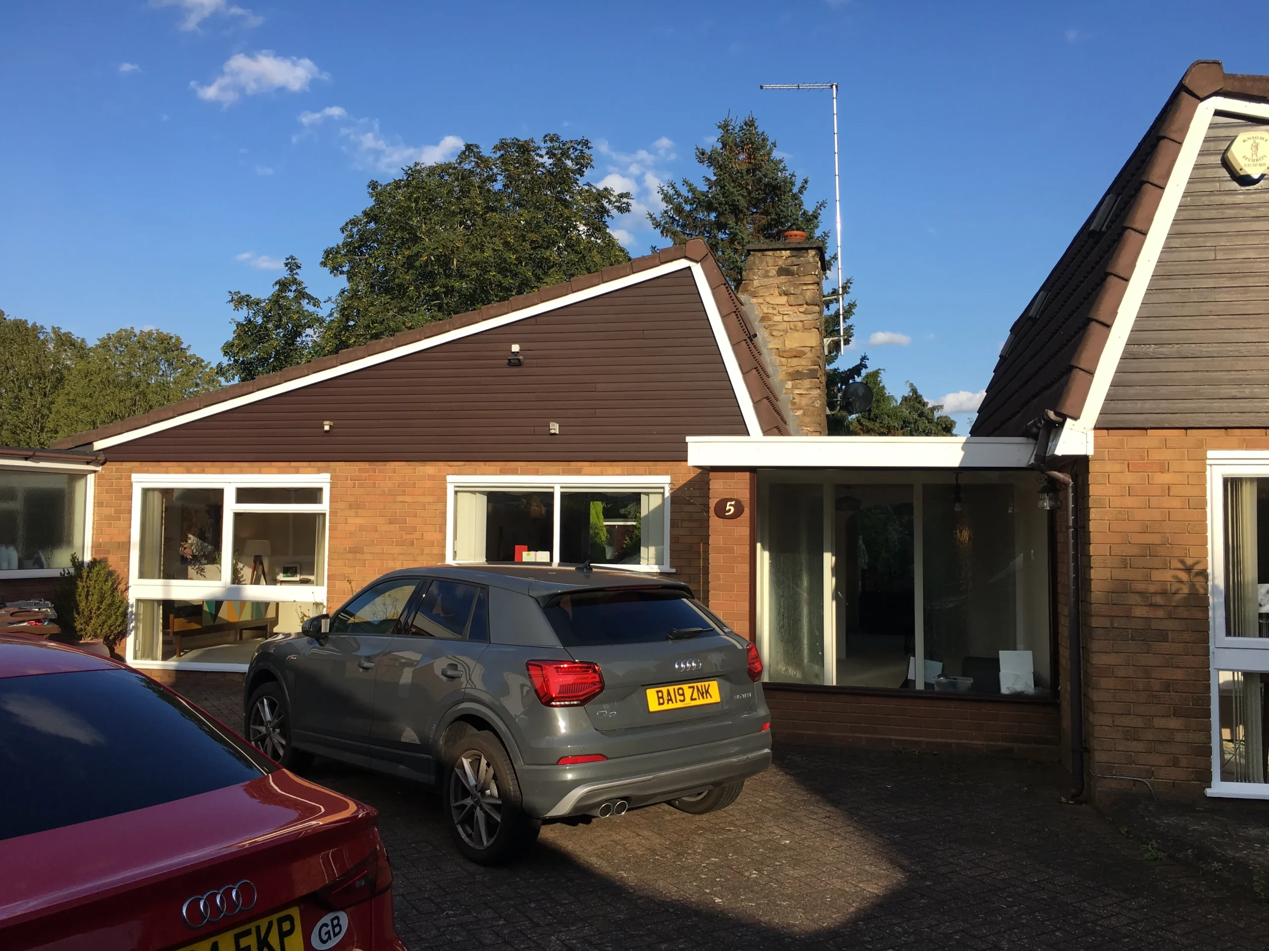 Existing view of the front entrance prior to remodelling, showing the social wing to the left and private wing to the right, linked by a flat-roofed entrance hall.